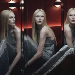 Modelo con cabello rubio y vestido plateado brillante, reflejada en espejos. Un diseño de Ludovic de Saint Sernin.