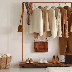 Un armario cápsula con prendas de punto, abrigos y bolsos en tonos tierra. Un ejemplo de cómo organizar tu ropa de forma eficiente.