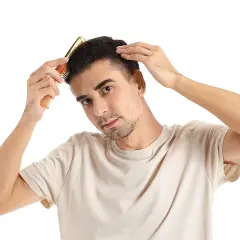 Hombre peinando su cabello, preocupado por en qué época se cae más el pelo.