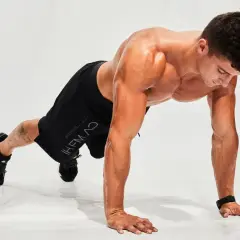 Hombre haciendo flexiones en posición de plancha, listo para un entrenamiento de hiit en casa.