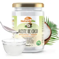 Un frasco de aceite de coco NaturaleBio con una cuchara vertiendo aceite en un cuenco. El aceite de coco es bueno para el pelo, nutriéndolo y dándole brillo.