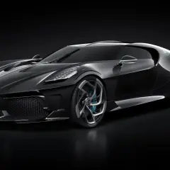 El Bugatti La Voiture Noire, un deportivo negro brillante con detalles plateados y llantas futuristas, se exhibe sobre un fondo oscuro.