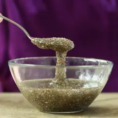 Cuchara levanta una porción gelatinosa de agua de chía de un cuenco de vidrio.