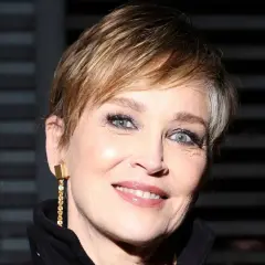 Señora sonríe con un moderno corte de cabello pixie, luciendo un elegante pendiente dorado.