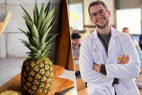 Un hombre sonriente con bata blanca y una piña entera en una tabla de cortar. ¿Será que la piña por la noche adelgaza?