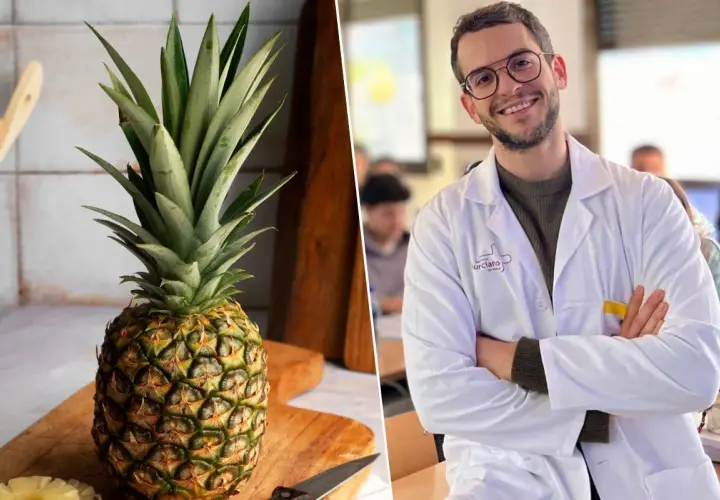 Un hombre sonriente con bata blanca y una piña entera en una tabla de cortar. ¿Será que la piña por la noche adelgaza?