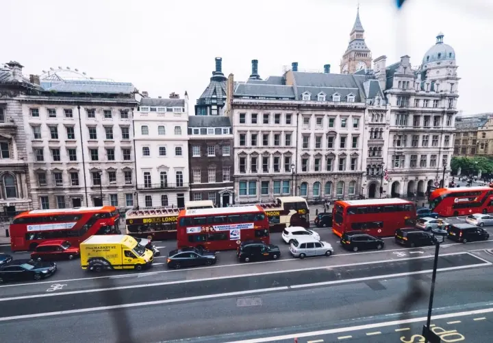 Autobuses rojos y taxis negros circulan por Londres, una escena que explica porque los ingleses conducen por la izquierda.