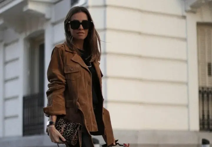 Mujer con chaqueta marrón y bolso estampado. El marron y negro combinan a la perfección en este look urbano.