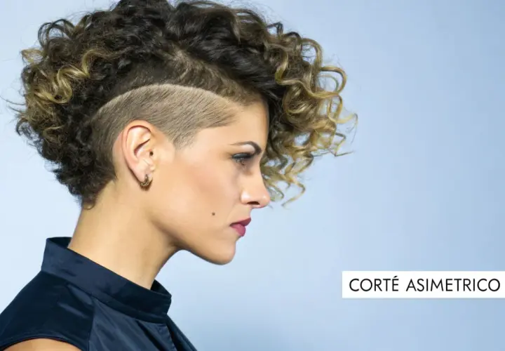 Mujer con pelo corto rizado y rapado asimétrico. Un estilo audaz que resalta su personalidad.