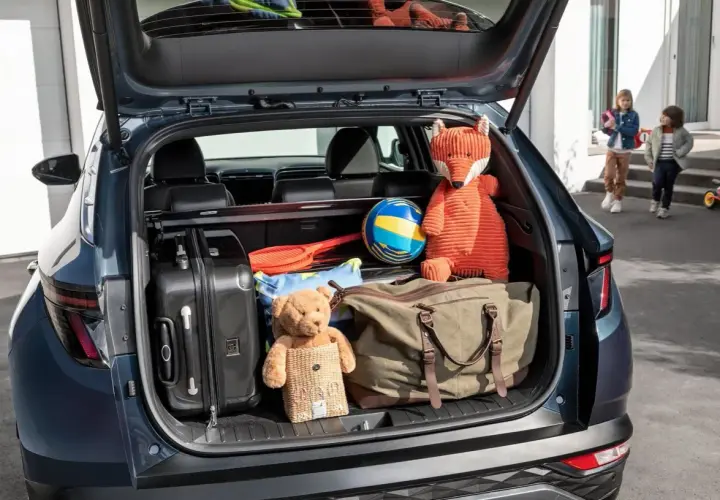 Maletero Hyundai Tucson listo para la aventura: maletas, peluches y un balón esperan.