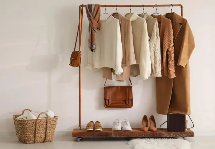 Un armario cápsula con prendas de punto, abrigos y bolsos en tonos tierra. Un ejemplo de cómo organizar tu ropa de forma eficiente.
