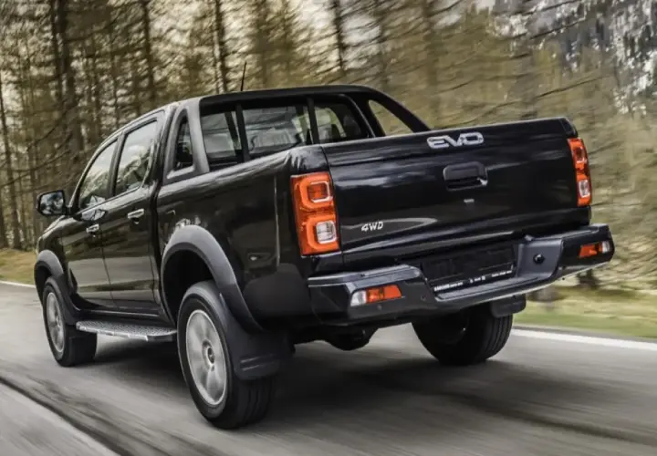 Camioneta negra 4WD en carretera boscosa. Buscando evo cross 4 opiniones para tu próxima aventura.