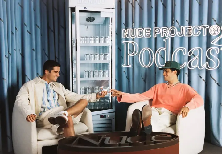 Dos jóvenes disfrutan de una bebida en el set del podcast de Nude Project.