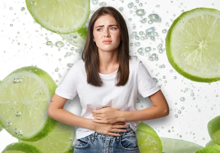 Mujer con cara de dolor, sujetándose el abdomen, rodeada de rodajas de limón y burbujas. ¿Será que el limón estriñe?