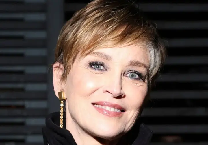 Señora sonríe con un moderno corte de cabello pixie, luciendo un elegante pendiente dorado.