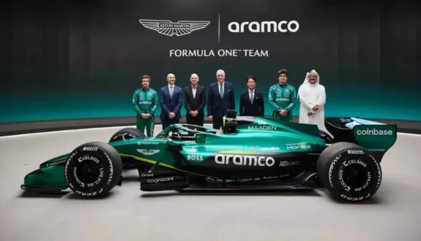 El nuevo Aston Martin F1, un coche verde brillante, posa junto a pilotos y directivos.