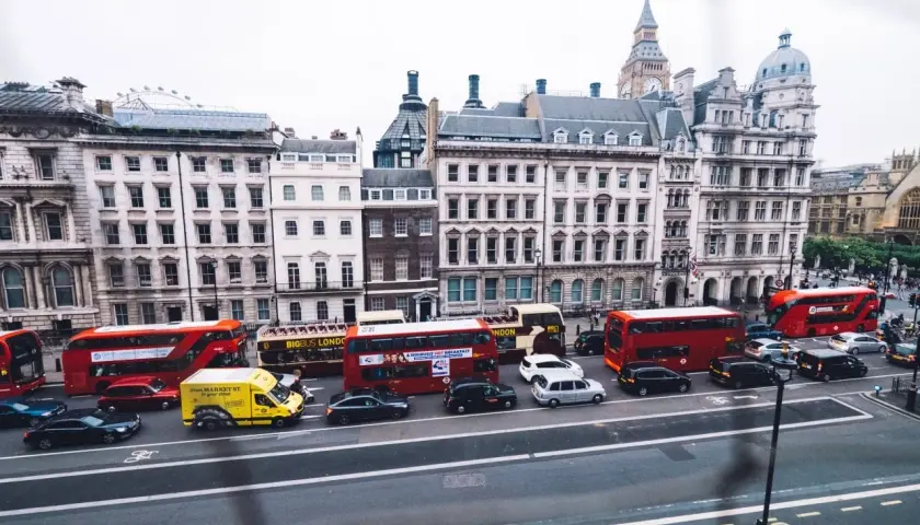 Autobuses rojos y taxis negros circulan por Londres, una escena que explica porque los ingleses conducen por la izquierda.