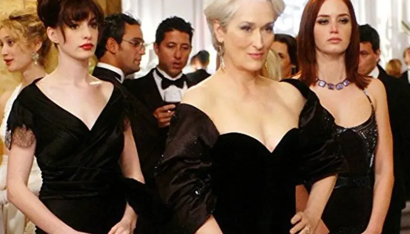 Anne Hathaway, Meryl Streep y Emily Blunt en un evento de gala, un momento icónico de las **películas de moda**.
