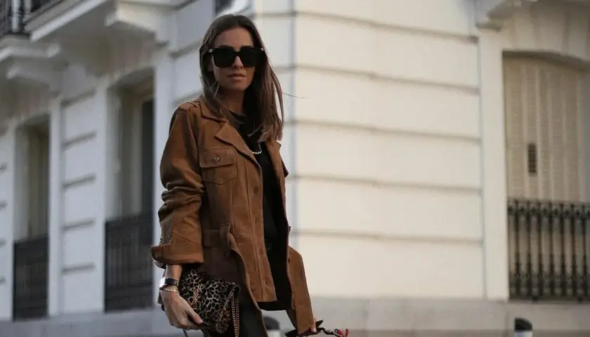 Mujer con chaqueta marrón y bolso estampado. El marron y negro combinan a la perfección en este look urbano.