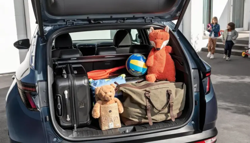 Maletero Hyundai Tucson listo para la aventura: maletas, peluches y un balón esperan.