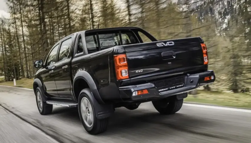 Camioneta negra 4WD en carretera boscosa. Buscando evo cross 4 opiniones para tu próxima aventura.