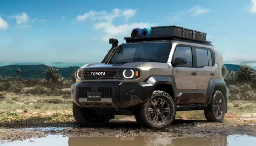 Un Toyota Land Cruiser FJ listo para la aventura, con equipo de campamento en el techo, avanza por un camino embarrado en un paisaje tropical.