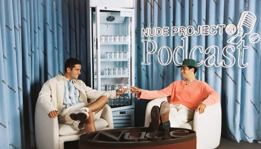 Dos jóvenes disfrutan de una bebida en el set del podcast de Nude Project.