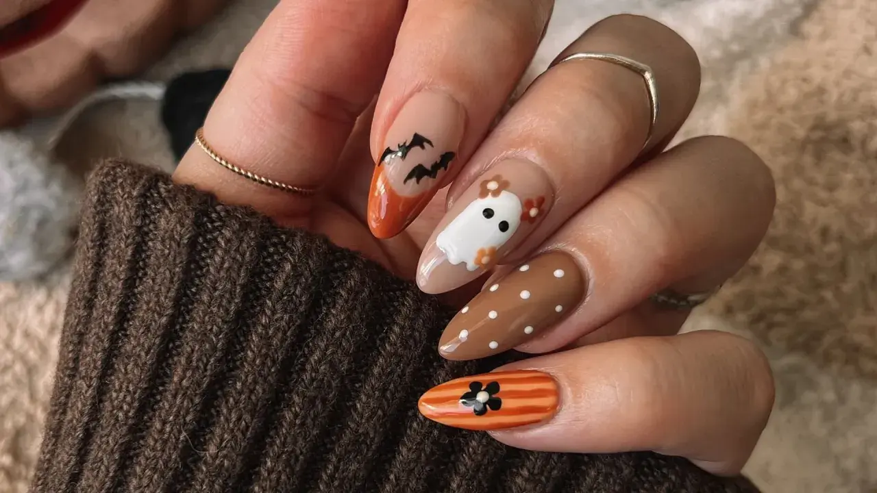 Uñas halloween sencillas con fantasmas, murciélagos y flores. Un diseño adorable y fácil para la noche de brujas.