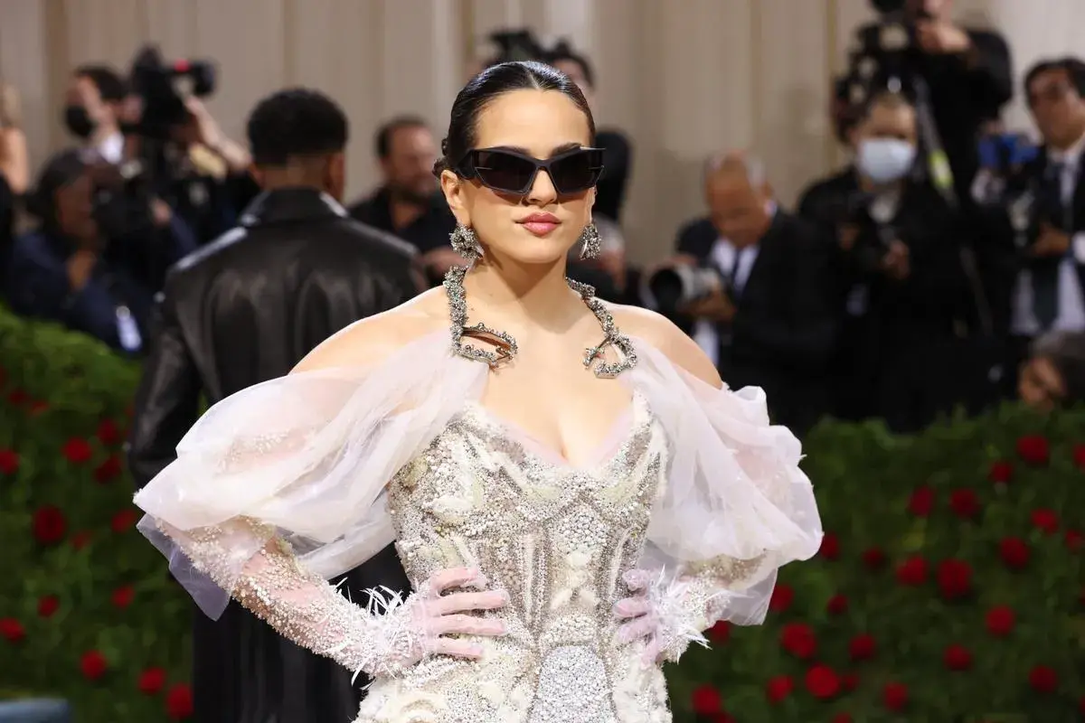 Rosalía deslumbró en la Met Gala con un vestido blanco adornado, gafas de sol y guantes.