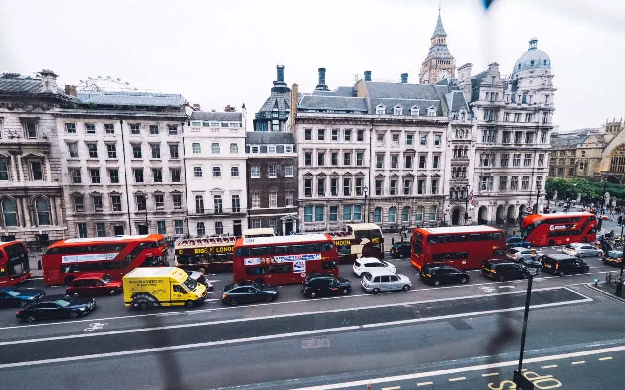 Autobuses rojos y taxis negros circulan por Londres, una escena que explica porque los ingleses conducen por la izquierda.
