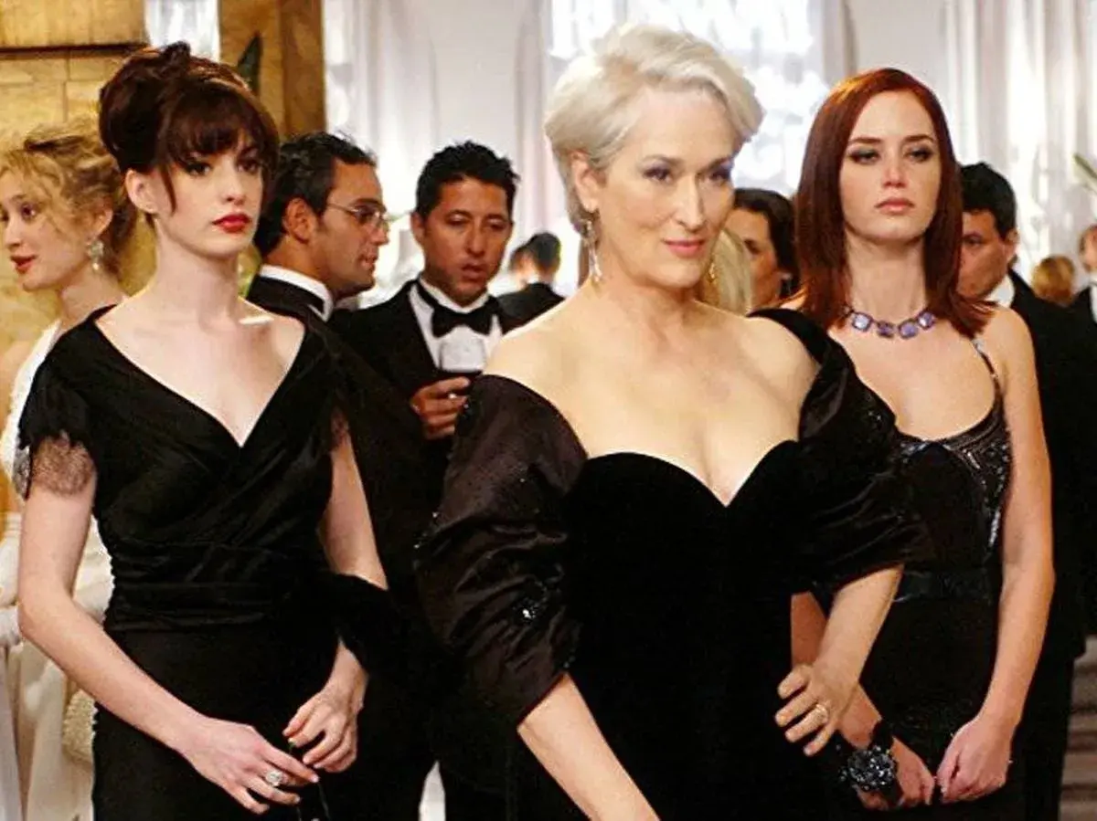 Anne Hathaway, Meryl Streep y Emily Blunt en un evento de gala, un momento icónico de las **películas de moda**.