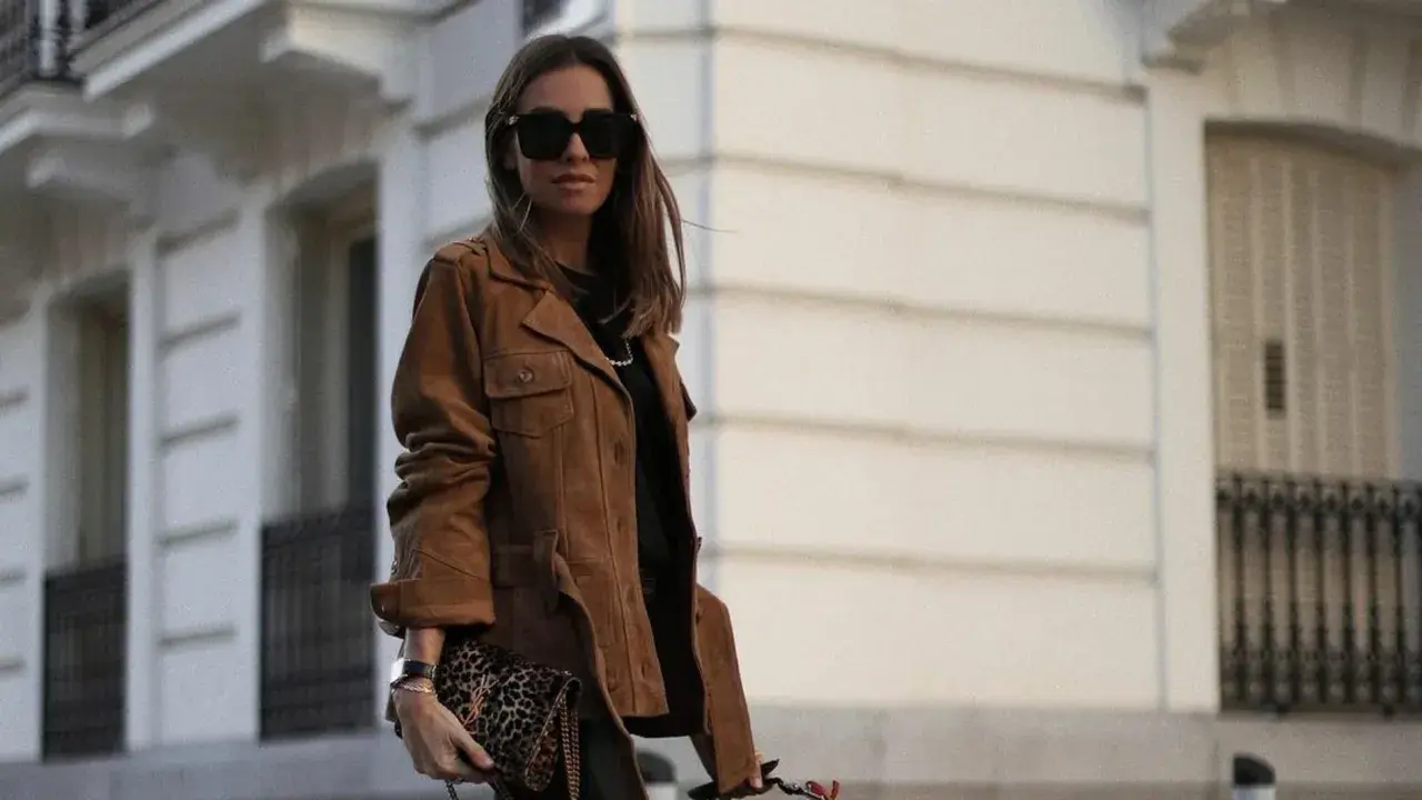 Mujer con chaqueta marrón y bolso estampado. El marron y negro combinan a la perfección en este look urbano.