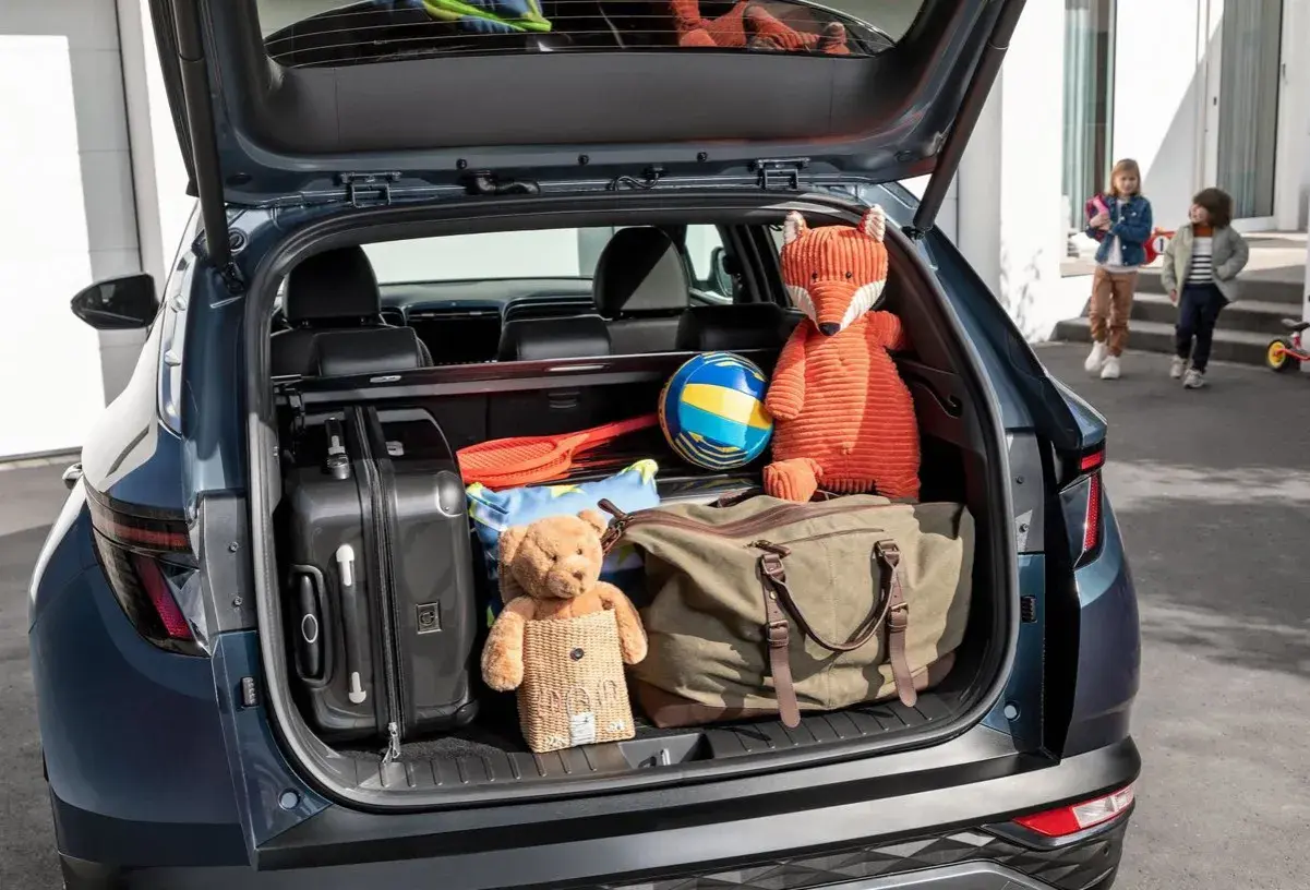 Maletero Hyundai Tucson listo para la aventura: maletas, peluches y un balón esperan.