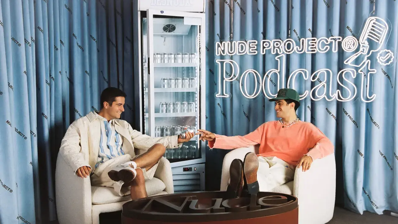Dos jóvenes disfrutan de una bebida en el set del podcast de Nude Project.
