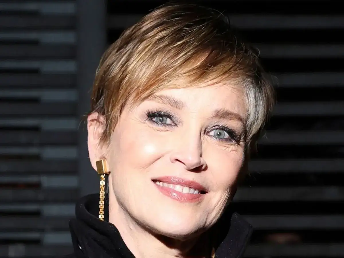 Se&ntilde;ora sonriente con un moderno corte de cabello pixie, luciendo un elegante pendiente dorado.