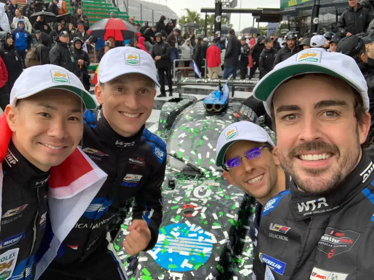 Fernando Alonso y su equipo celebran en Daytona, cubiertos de confeti tras una carrera.