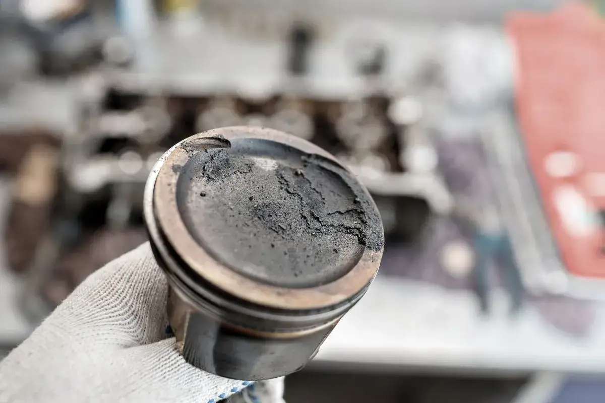 Pist&oacute;n con carbonilla acumulada, un problema com&uacute;n que puede requerir remedios caseros para quitar la carbonilla del coche.