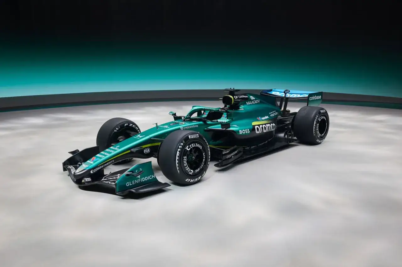 El nuevo Aston Martin F1, un coche de carreras verde esmeralda con detalles amarillos y patrocinadores como Coinbase y BOSS, listo para la velocidad.