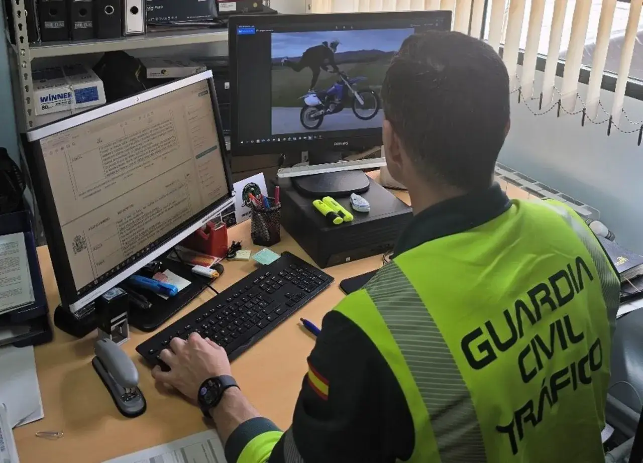 Agente de la Guardia Civil revisa en pantalla un video de alguien conduciendo de forma temeraria una moto.