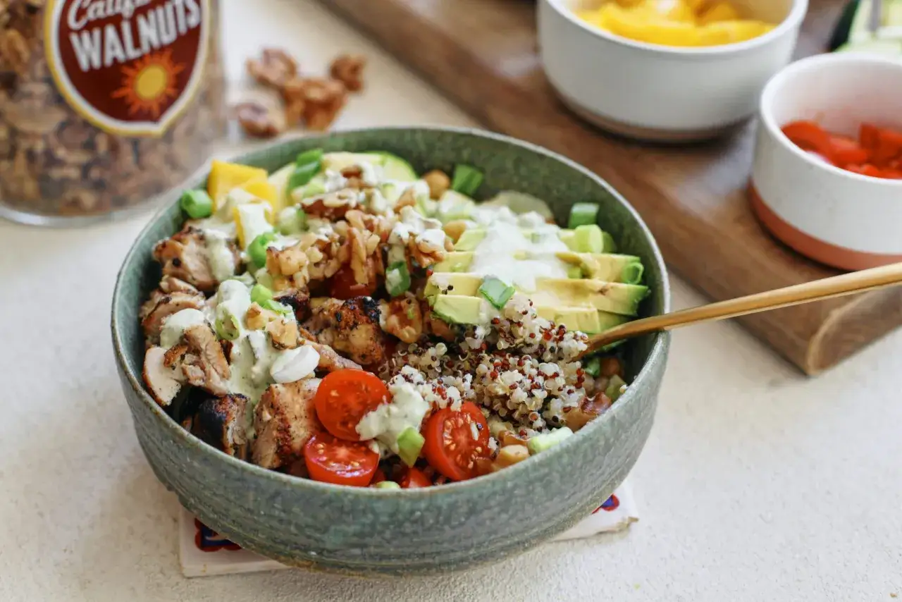 Bowl con pollo, quinoa, aguacate, tomates y nueces. Una opción saludable de alimentos quema grasa por la noche.