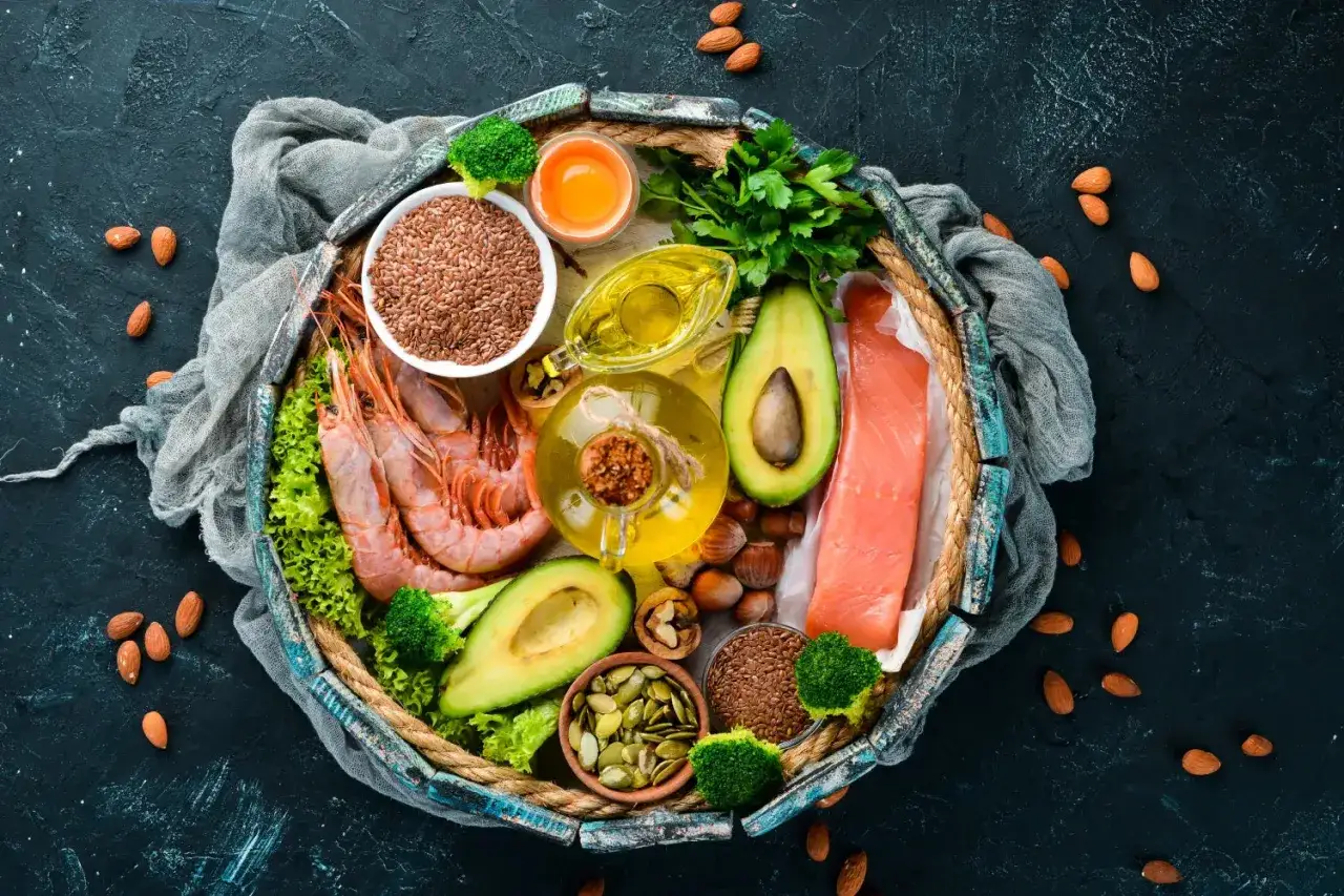 Bandeja con salmón, gambas, aguacate, semillas de lino y calabaza, frutos secos y aceite. ¡Una dieta rica en omega 7 adelgaza!