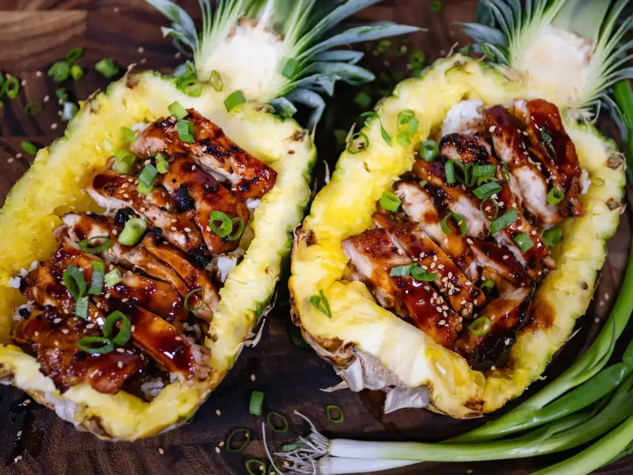 Dos mitades de pi&ntilde;a rellenas de arroz y pollo teriyaki, adornadas con cebolleta. &iexcl;Una cena deliciosa que te har&aacute; sentir ligero, como si la pi&ntilde;a por la noche adelgazara!