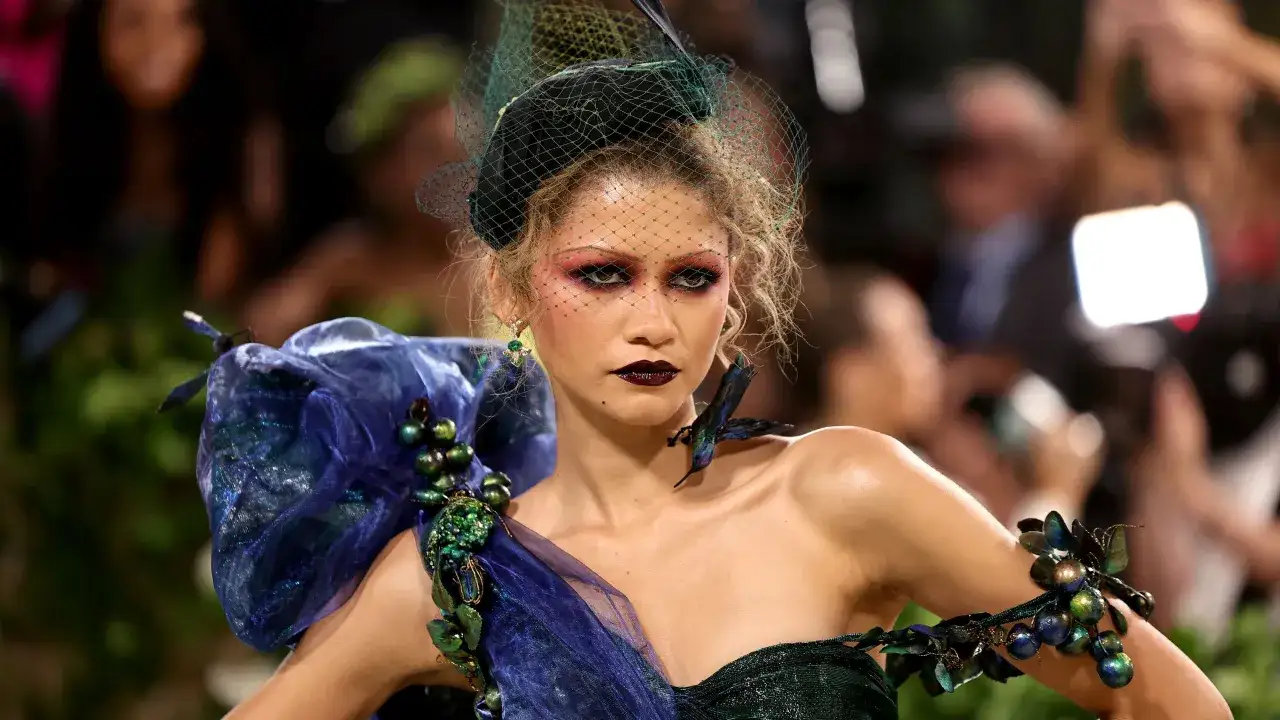 Zendaya deslumbrante en la Met Gala, con un vestido verde oscuro y velo, luciendo un maquillaje dram&aacute;tico y joyas inspiradas en la naturaleza.